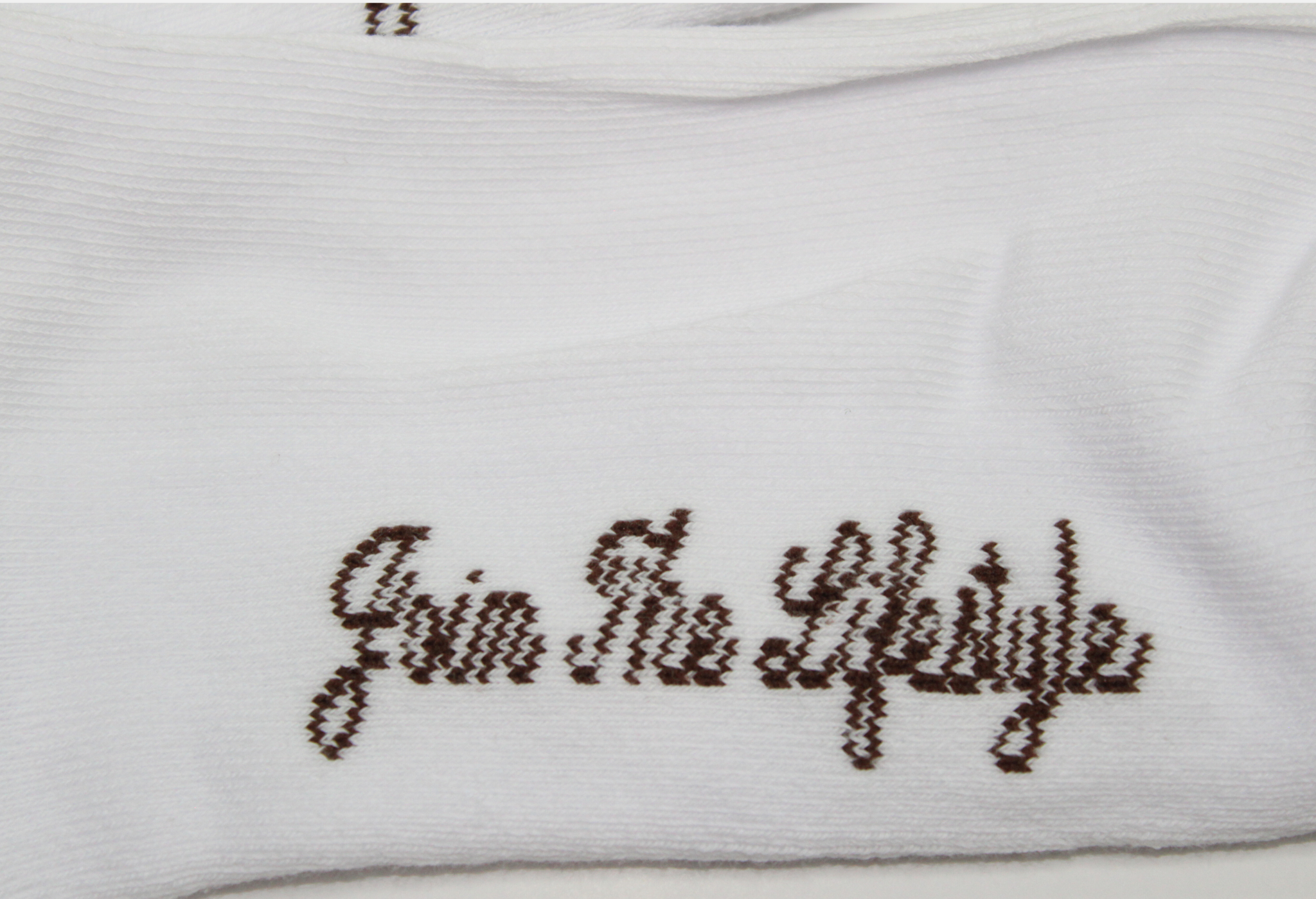 White sock with brown text 'Join The Lifestyle' on a white background